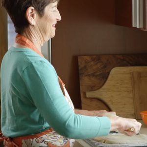 woman rolling dough in kitchen